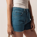 Short Curto Barra Desfiada Jeans Médio Claro Eco Denim™. Compre online moda sustentável e atemporal na Minimadeia. Roupas femininas estilosas, básicas e sustentáveis. Foto produto 03