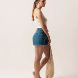 Short Curto Barra Desfiada Jeans Médio Claro Eco Denim™. Compre online moda sustentável e atemporal na Minimadeia. Roupas femininas estilosas, básicas e sustentáveis. Foto produto 04
