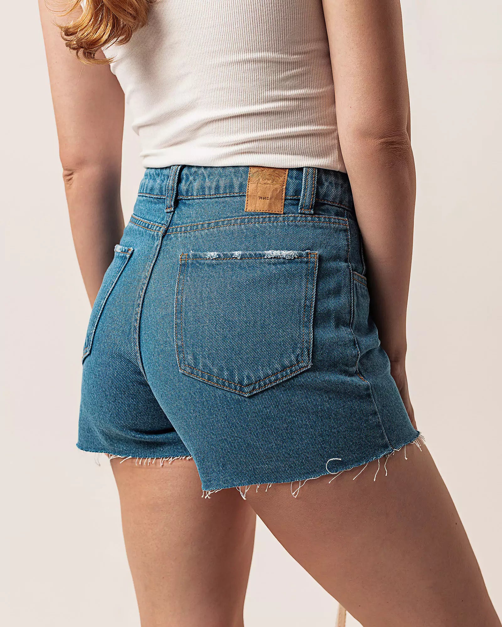 Short Curto Barra Desfiada Jeans Médio Claro Eco Denim™. Compre online moda sustentável e atemporal na Minimadeia. Roupas femininas estilosas, básicas e sustentáveis. Foto produto 02